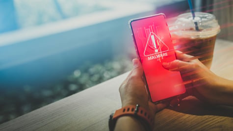 Close up hand of smartphone with malware warning